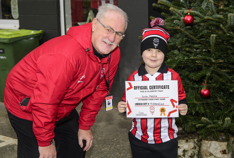 A young boy holds a certificate