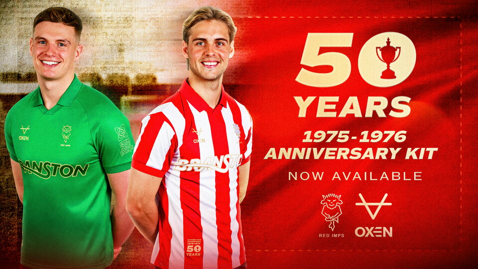 Two men pose in retro football shirts. One is a green goalkeeper top, the other is a red and white striped top.