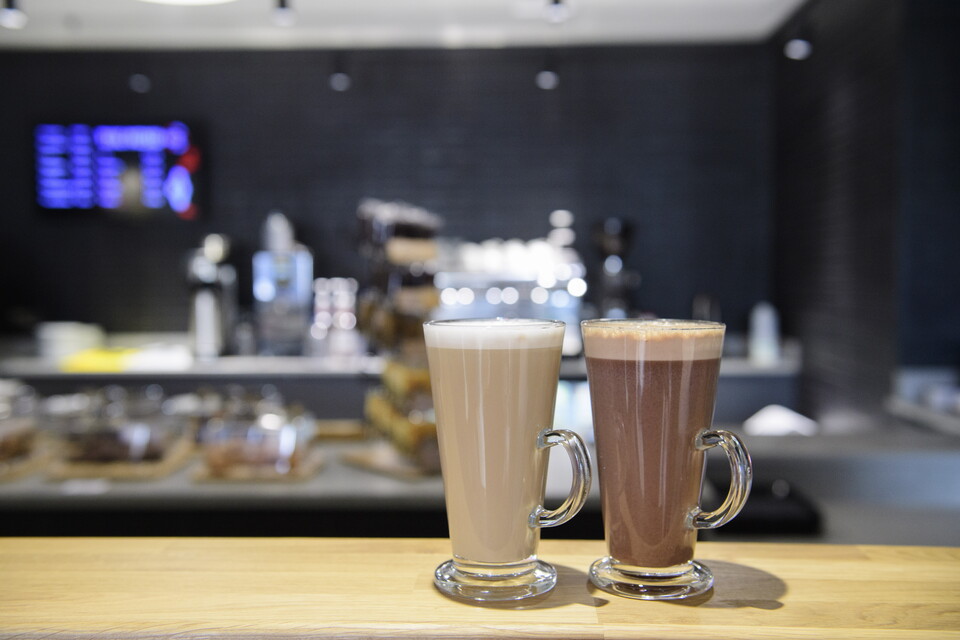 Coffees on a counter with a general coffee shop backround
