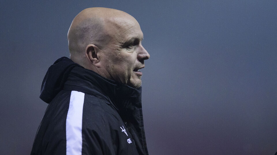 Lincoln City's Academy & Women's technical director Jon Pepper. He is wearing a black coat with a white stripe down an arm.