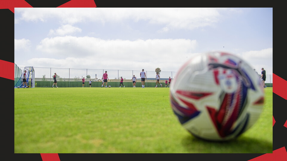 A football is pictured as Lincoln City's players are training in the background.