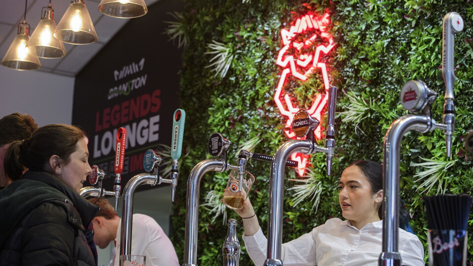 A woman pours a pint in the Legends Lounge at the LNER Stadium.