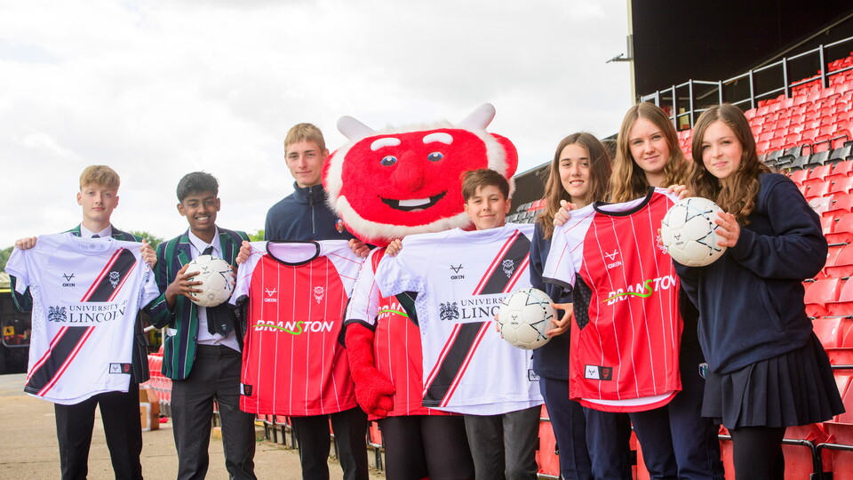 Students from Lincoln Minster pictured with Poacher the Imp after being donated shirts by Lincoln City