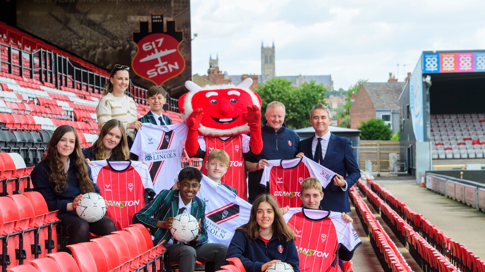 Students from Lincoln Minster pictured with Poacher the Imp after being donated shirts by Lincoln City