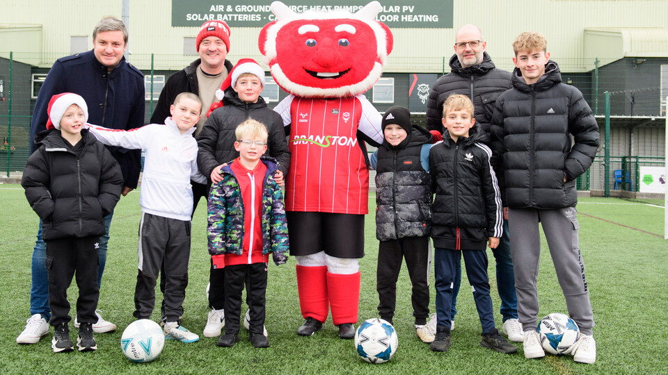 Lincoln City supporters pose in a group with Poacher the Imp 