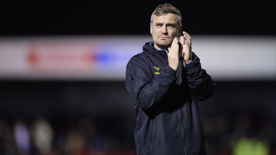 Michael Skubala applauds supporters. He is wearing a black rain jacket.