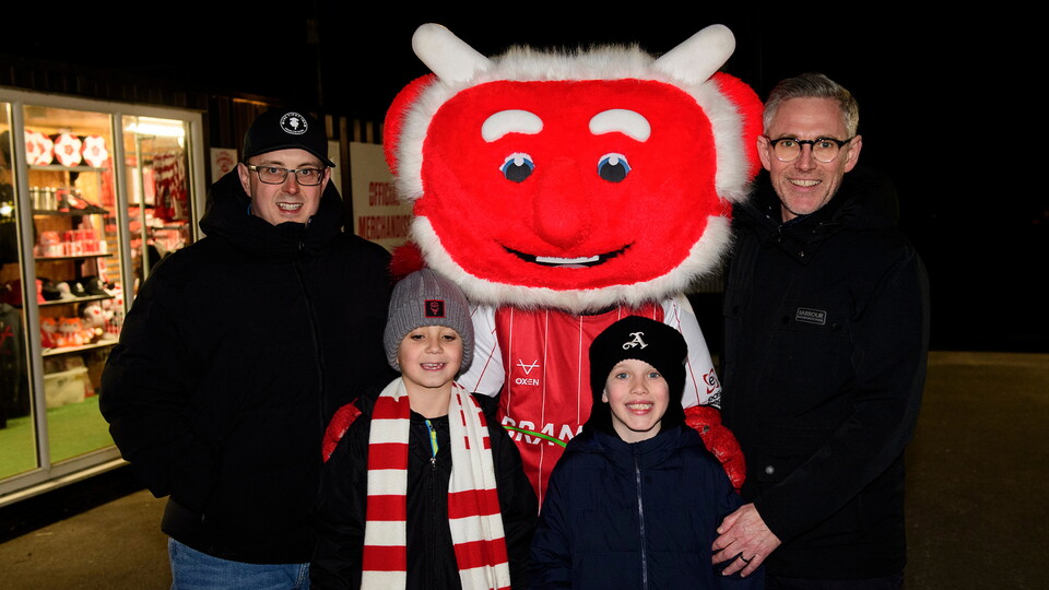 Lincoln City fans pose with Poacher the Imp outside the LNER Stadium