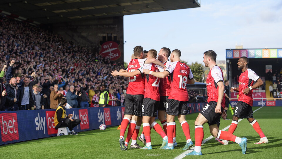Lincoln City players celebrate after scoring a goal