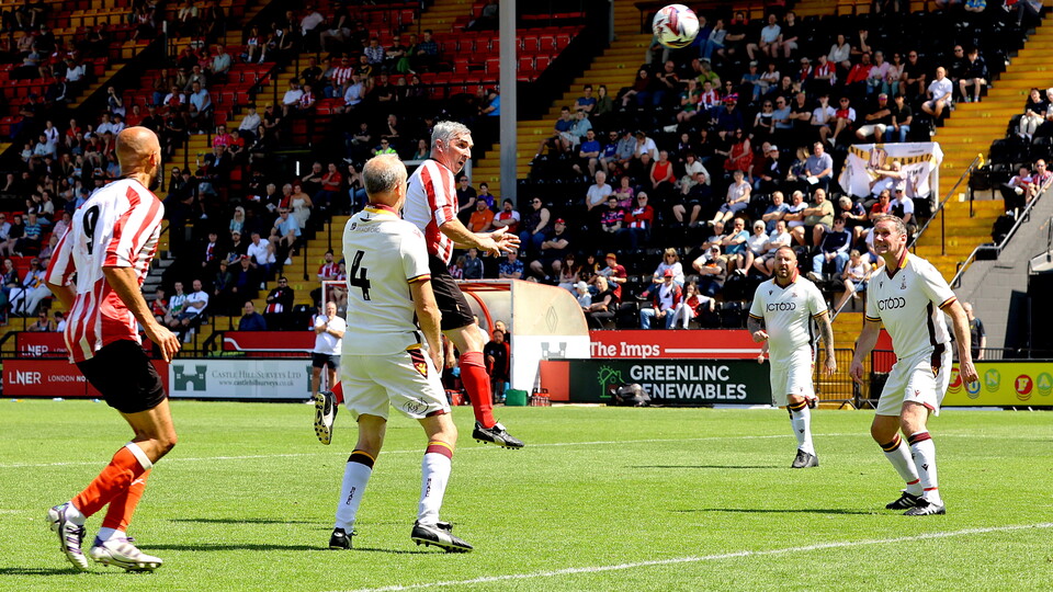 Simon Yeo heads the football towards goal.