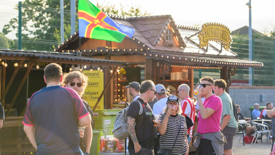 A picture of supporters outside a food vendor at the Fan Village located at the LNER Stadium.