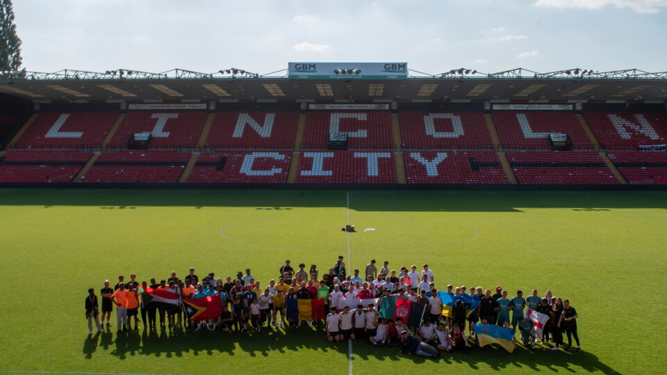 A group photograph of the Community World Cup players taken at the LNER Stadium.