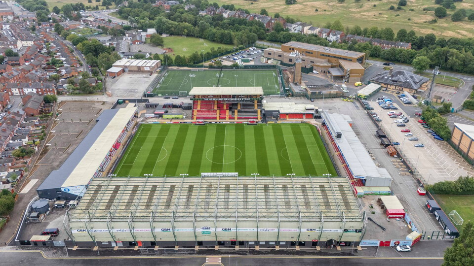 An aerial general view of LNER Stadium, home of Lincoln City, showing the exterior of the GBM Stand, Stacey West Stand, left, Greenlinc Renewables Stand, including the 3G astroturf centre, and Rilmac Stand, right, prior to the pre-season friendly match between Lincoln City and West Bromwich Albion at LNER Stadium, Lincoln.