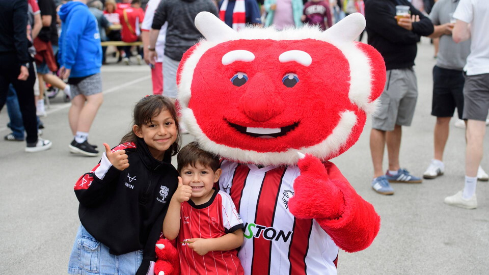 Poacher the Imp, mascot of Lincoln City with fans at LNER Stadium, Lincoln.