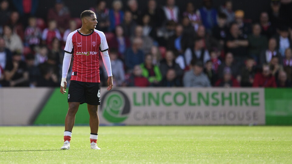 Ethan Erhahon stands on a football pitch 