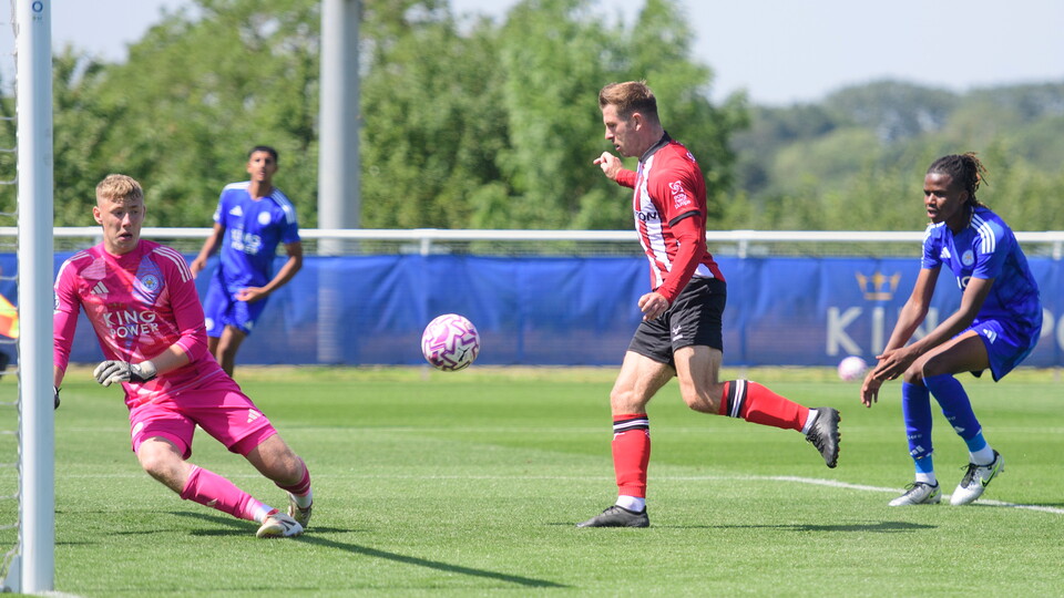 James Collins stands with a football in front of him as he scores for Lincoln City against Leicester City U21