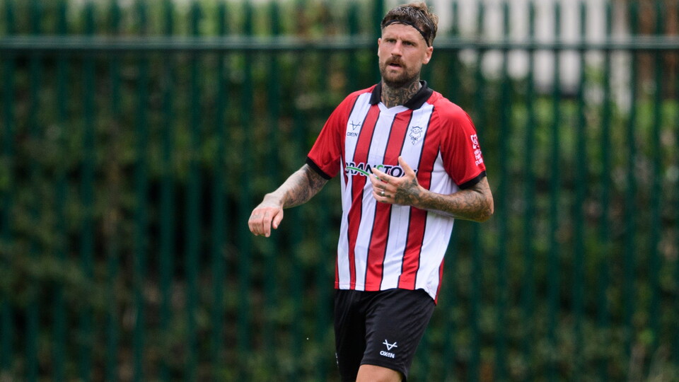 Sonny Bradley in a red and white striped football top.