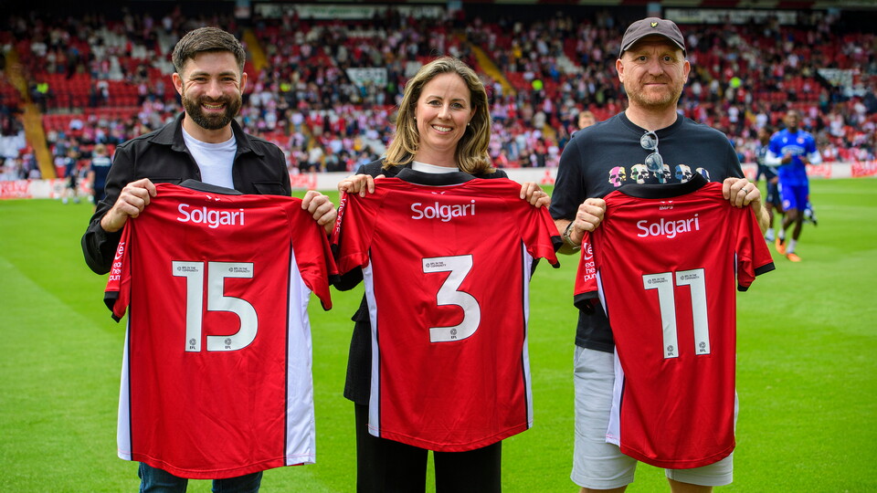Three people holding Lincoln City shirts