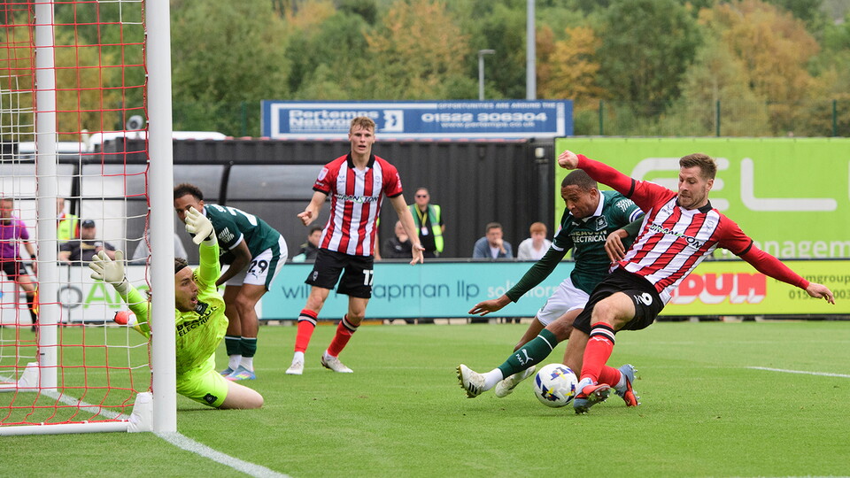 James Collins slots home a goal for Lincoln City against Plymouth Argyle