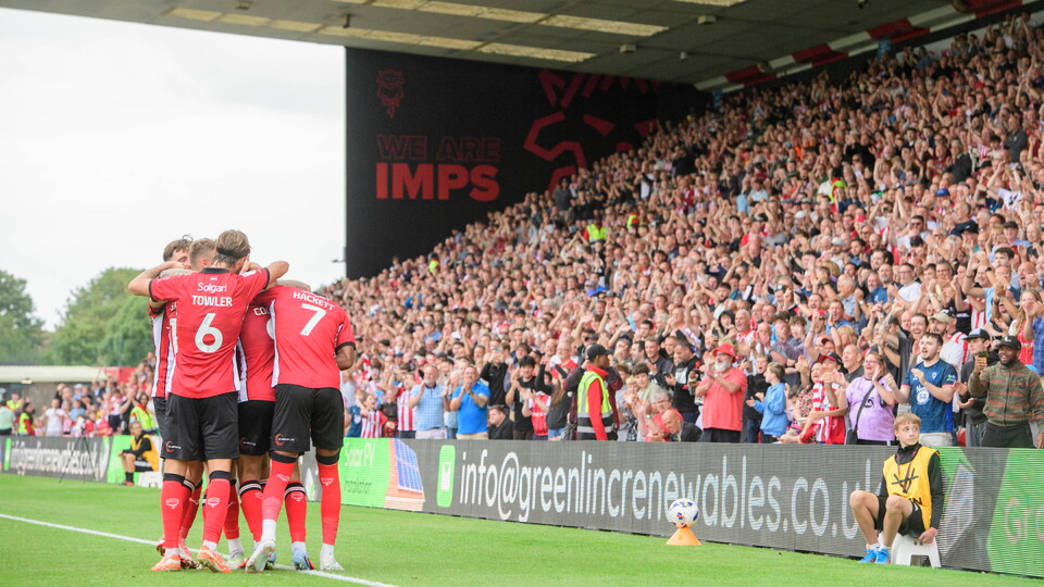 James Collins of Lincoln City celebrates scoring his side's third goal, from the penalty spot, with team-mates during the EFL Sky Bet League One match between Lincoln City and Plymouth Argyle at LNER Stadium, Lincoln.