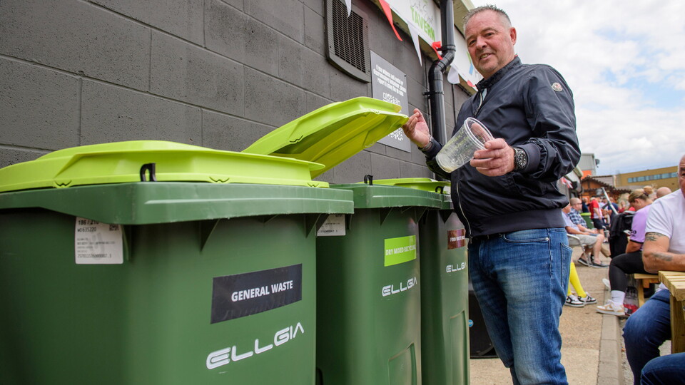 A Lincoln City fan uses a Ellgia bin in the fan village prior to the EFL Sky Bet League One match between Lincoln City and Reading at LNER Stadium, Lincoln.