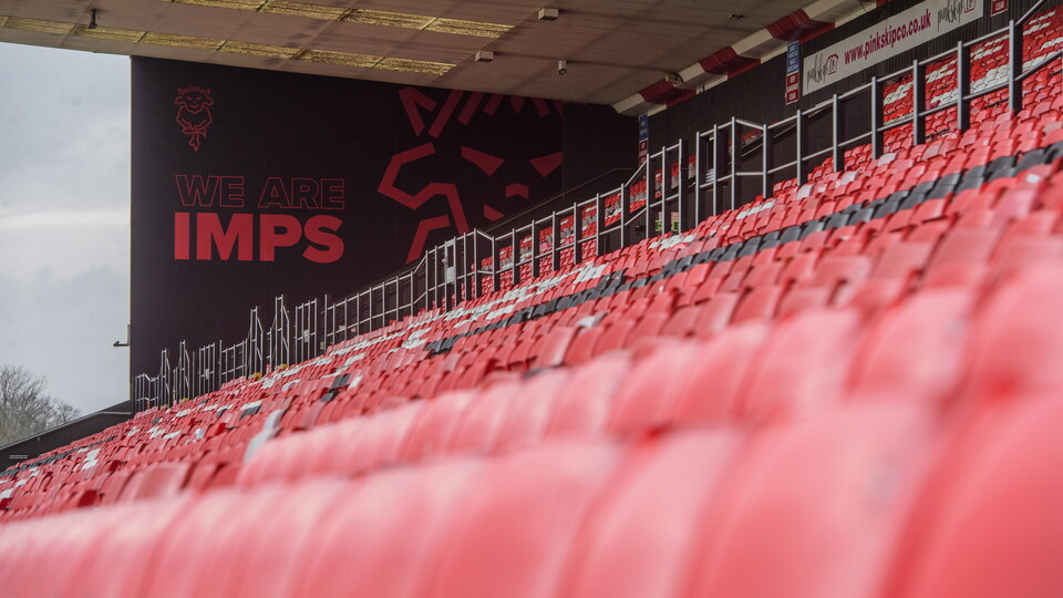 A mural which reads "We Are Imps" with rows of red seats in front of it