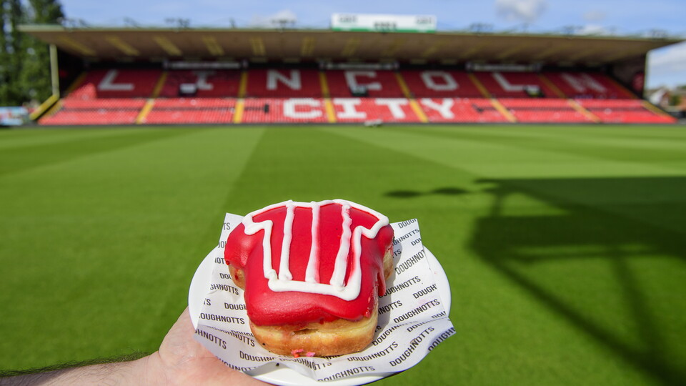 A donut in the shape of a shirt with red icing