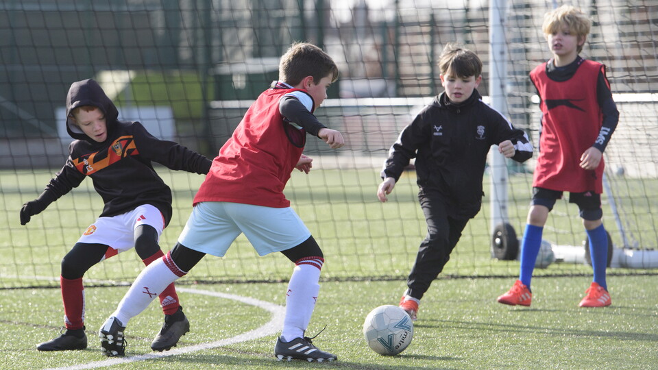 Children play football on a 3G pitch