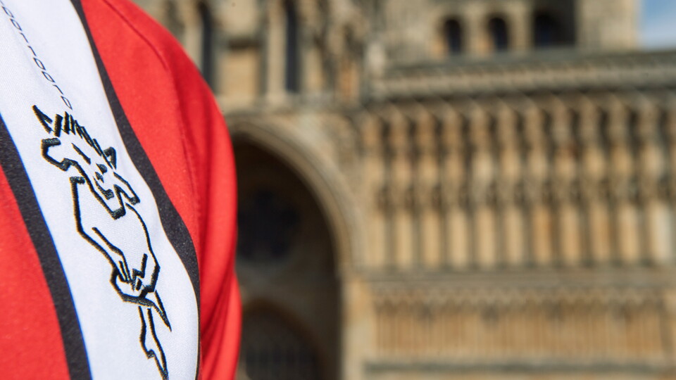 A close up of the Lincoln City badge on a shirt. In the background is Lincoln Cathedral