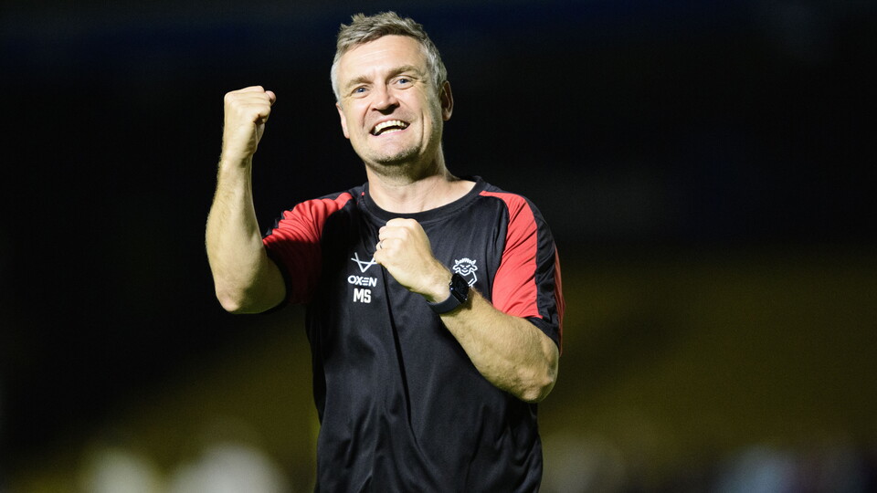 Michael Skubala holds his right arm up as he fistbumps supporters