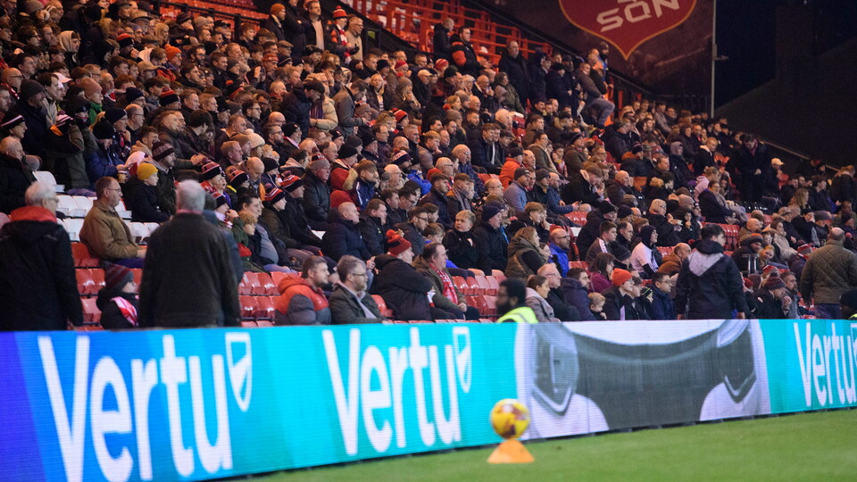 A Vertu LED advertising board in front of a crowd of football fans