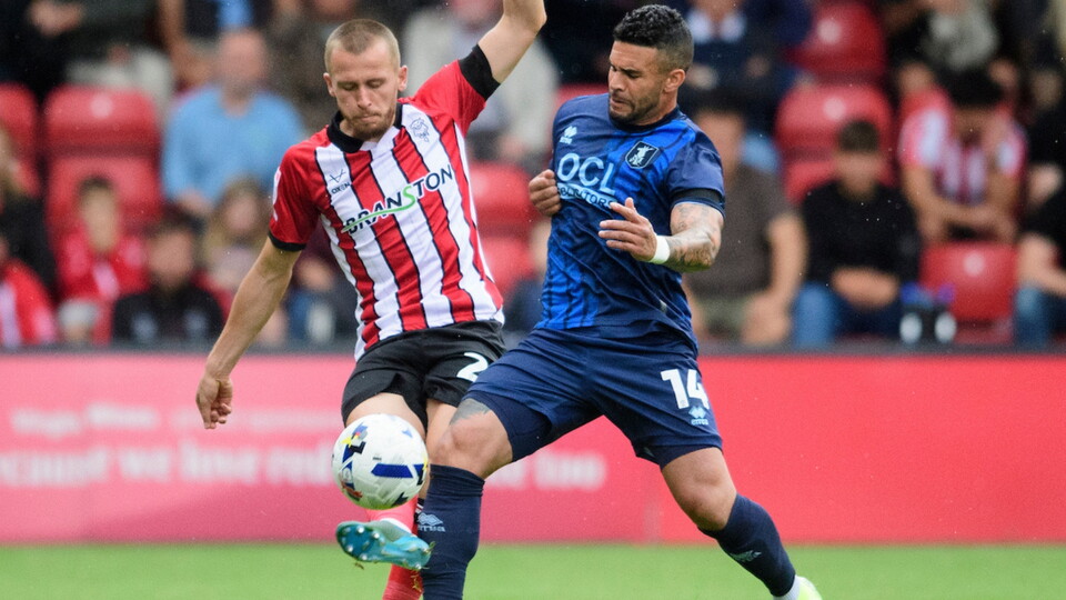 Tom Hamer of Lincoln City vies for possession with Dom Dwyer of Mansfield Town during the EFL Sky Bet League One match between Lincoln City and Mansfield Town at LNER Stadium, Lincoln.