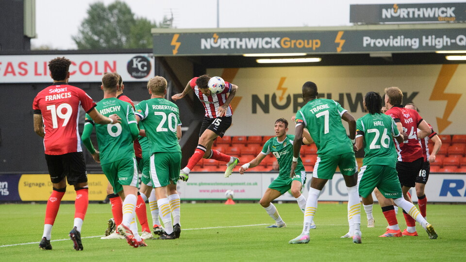 Sonny Bradley of Lincoln City scores the opening goal during the Vertu Trophy Northern Section group D match between Lincoln City and Notts County at LNER Stadium, Lincoln.