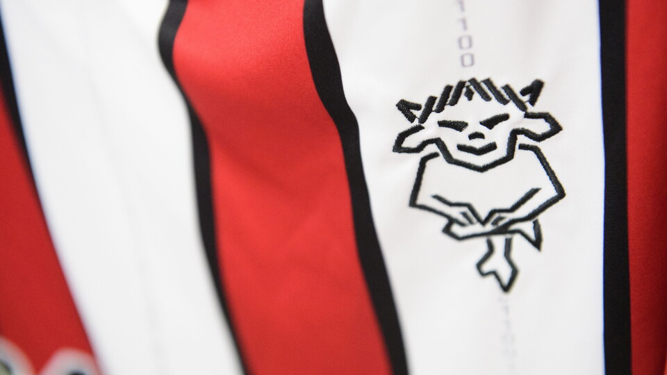A close up of the Lincoln City club badge on a home shirt.  