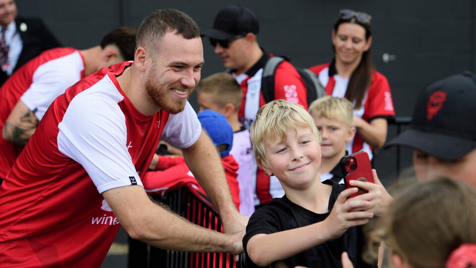 Ben House of Lincoln City poses for a selfie with a fan prior to the EFL Sky Bet League One match between Lincoln City and Wigan Athletic at LNER Stadium, Lincoln.