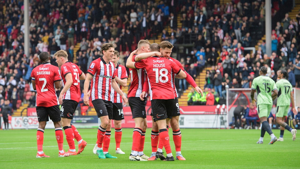 Ben House of Lincoln City, centre, celebrates scoring the opening goal with team-mates Rob Street, left, and James Collins during the EFL Sky Bet League One match between Lincoln City and Luton Town at LNER Stadium, Lincolnshire.