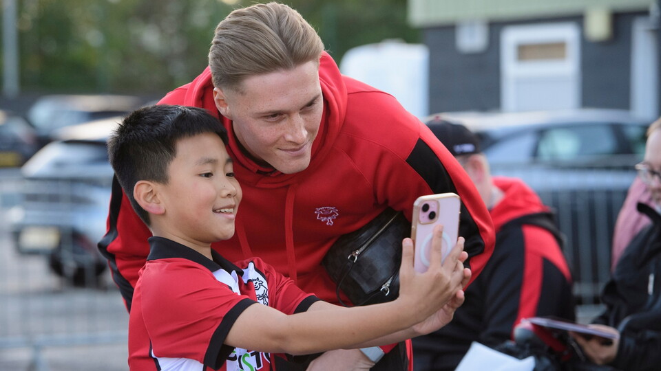 Zach Jeacock of Lincoln City poses for a selfie with a fan prior to the Carabao Cup third round match between Lincoln City and Chelsea at LNER Stadium, Lincolnshire.
