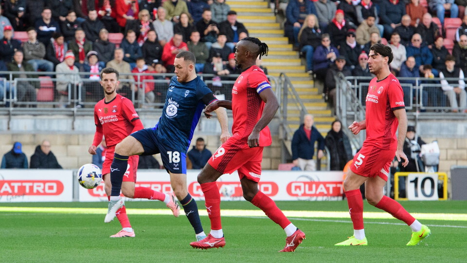 Ben House gets a shot away under pressure from a number of opposition players