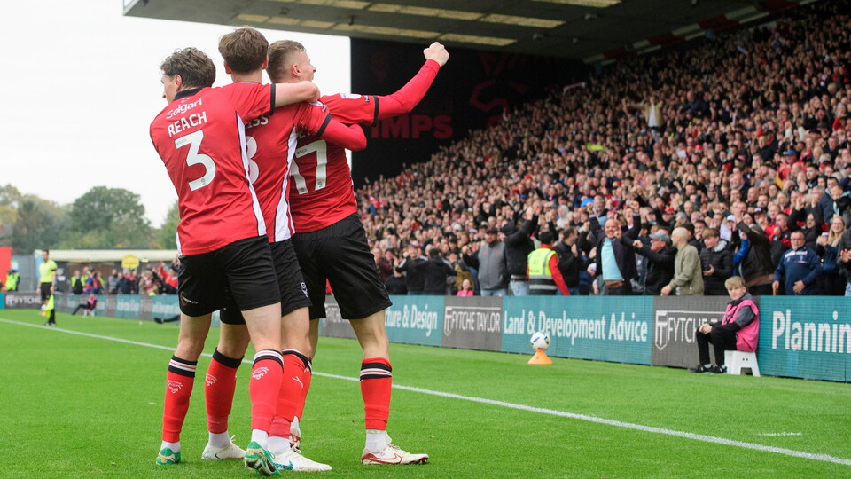 Rob Street of Lincoln City, right, celebrates scoring the opening goal with team-mates, Adam Reach, left, and Tom Bayliss during the EFL Sky Bet League One match between Lincoln City and Stevenage at LNER Stadium, Lincoln.