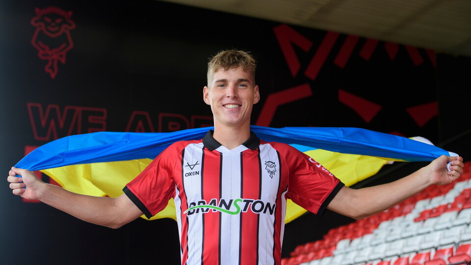 Ivan Varfolomeev of Lincoln City, photographed at the club’s LNER Stadium holding a Ukraine flag.