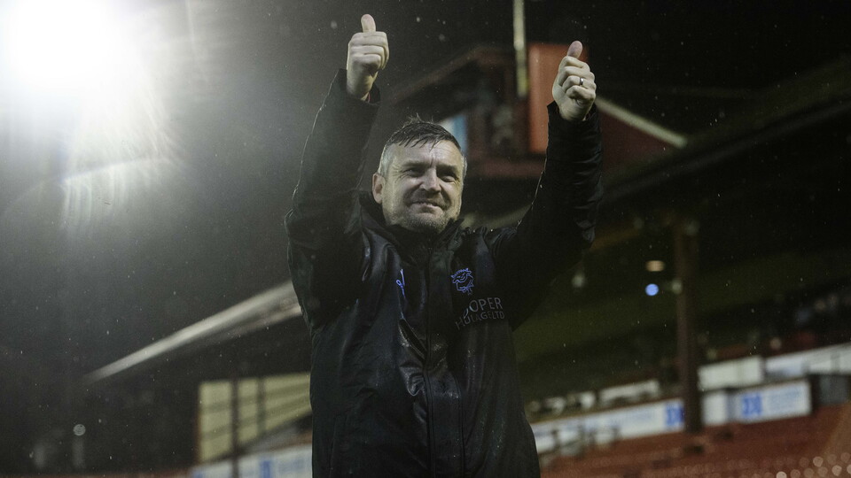 Michael Skubala holds both hands up, giving a thumbs up gesture.