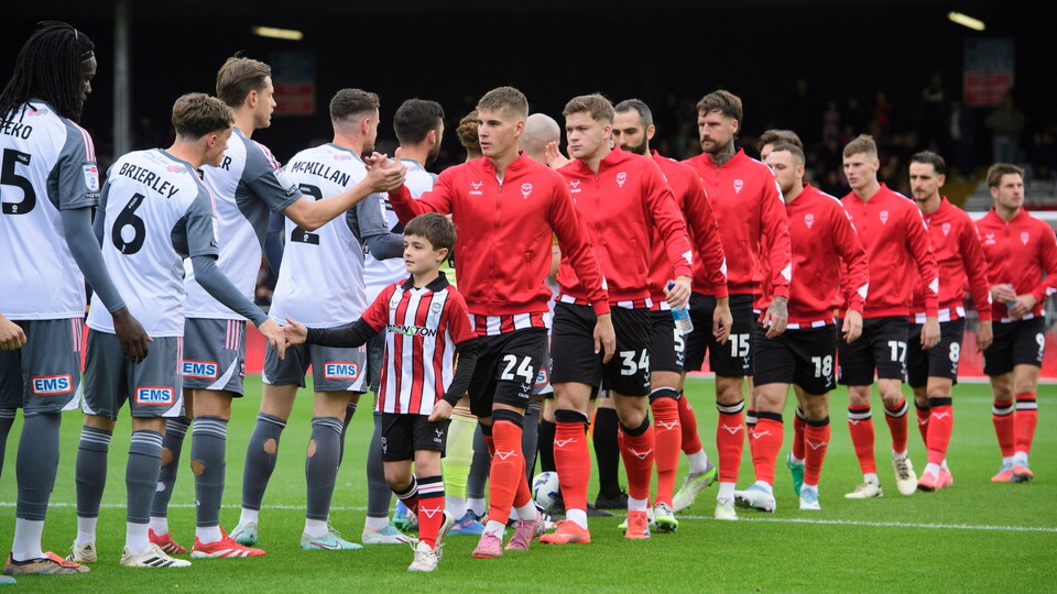 Ivan Varfolomeev of Lincoln City and a matchday mascot shakes hands with the Exeter City players prior to the EFL Sky Bet League One match between Lincoln City and Exeter City at LNER Stadium, Lincoln.