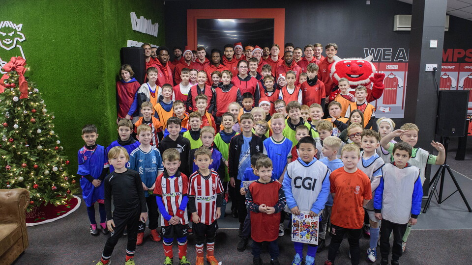 Lincoln City players and children pose for a group photo