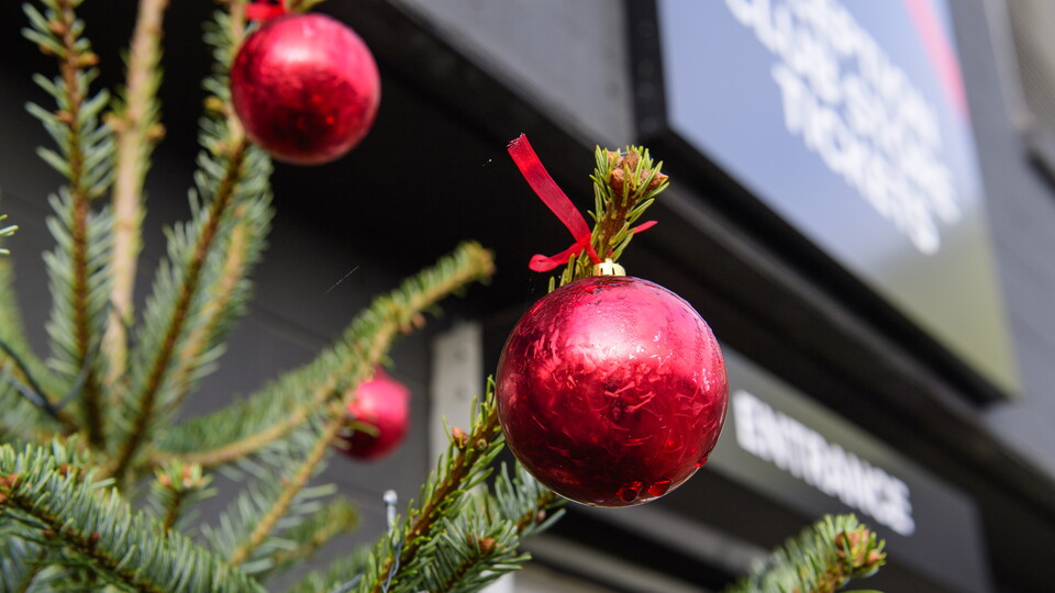 A Christmas tree in front of an entrance sign