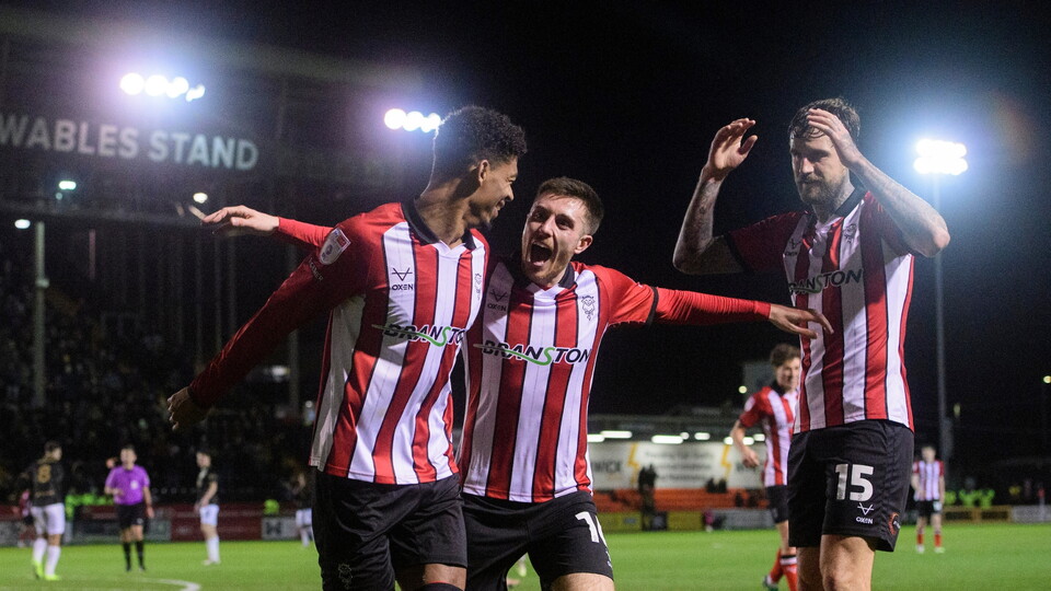 Reeco Hackett of Lincoln City, left, celebrates scoring his side's third goal with team-mate Dom Jefferies during the EFL Sky Bet League One match between Lincoln City and Barnsley at LNER Stadium, Lincoln.