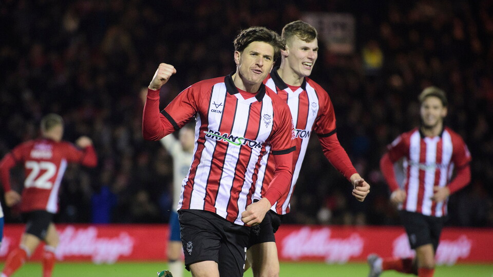 Adam Reach of Lincoln City, left, celebrates scoring his side's equalising goal to make the score 1-1, with team-mate Rob Street during the EFL Sky Bet League One match between Lincoln City and Huddersfield Town at LNER Stadium, Lincoln.