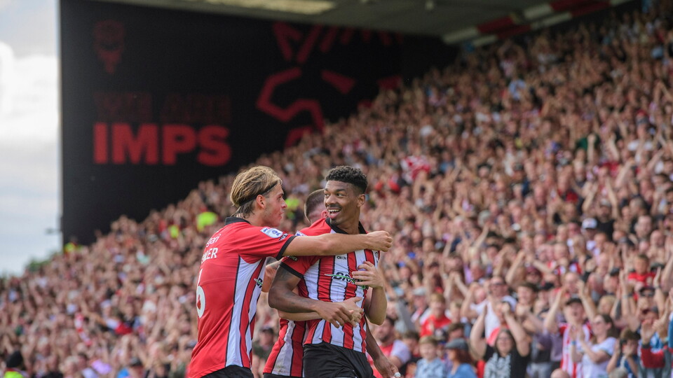 Reeco Hackett of Lincoln City, right, celebrates scoring his side's second goal with team-mate Ryley Towler during the EFL Sky Bet League One match between Lincoln City and Reading at LNER Stadium, Lincoln.