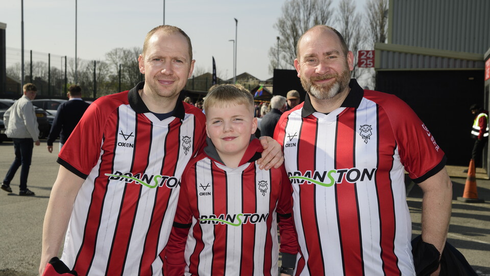 A family of three pose in the Fan Village