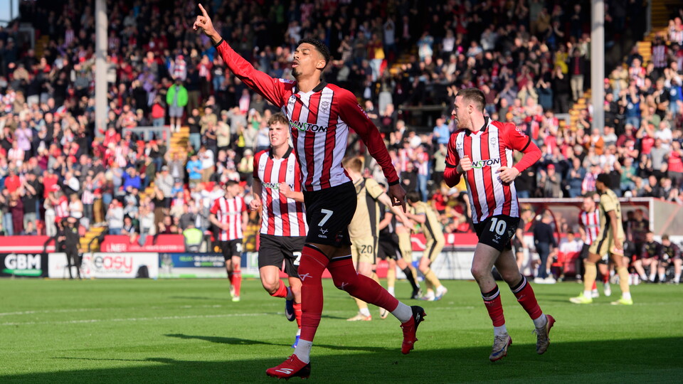 Reeco Hackett runs away with his right hand up to celebrate a goal