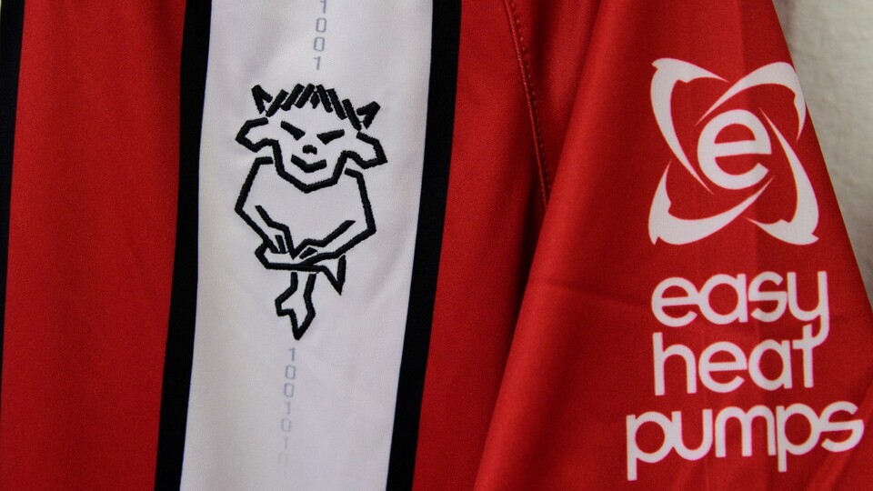 Red and white sports jersey with a black Imps logo on the front stripe. "Easy Heat Pumps" sponsor logo is printed on the sleeve.