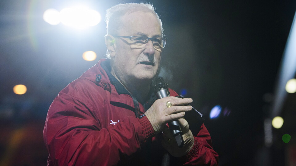 Alan Long holds a microphone.